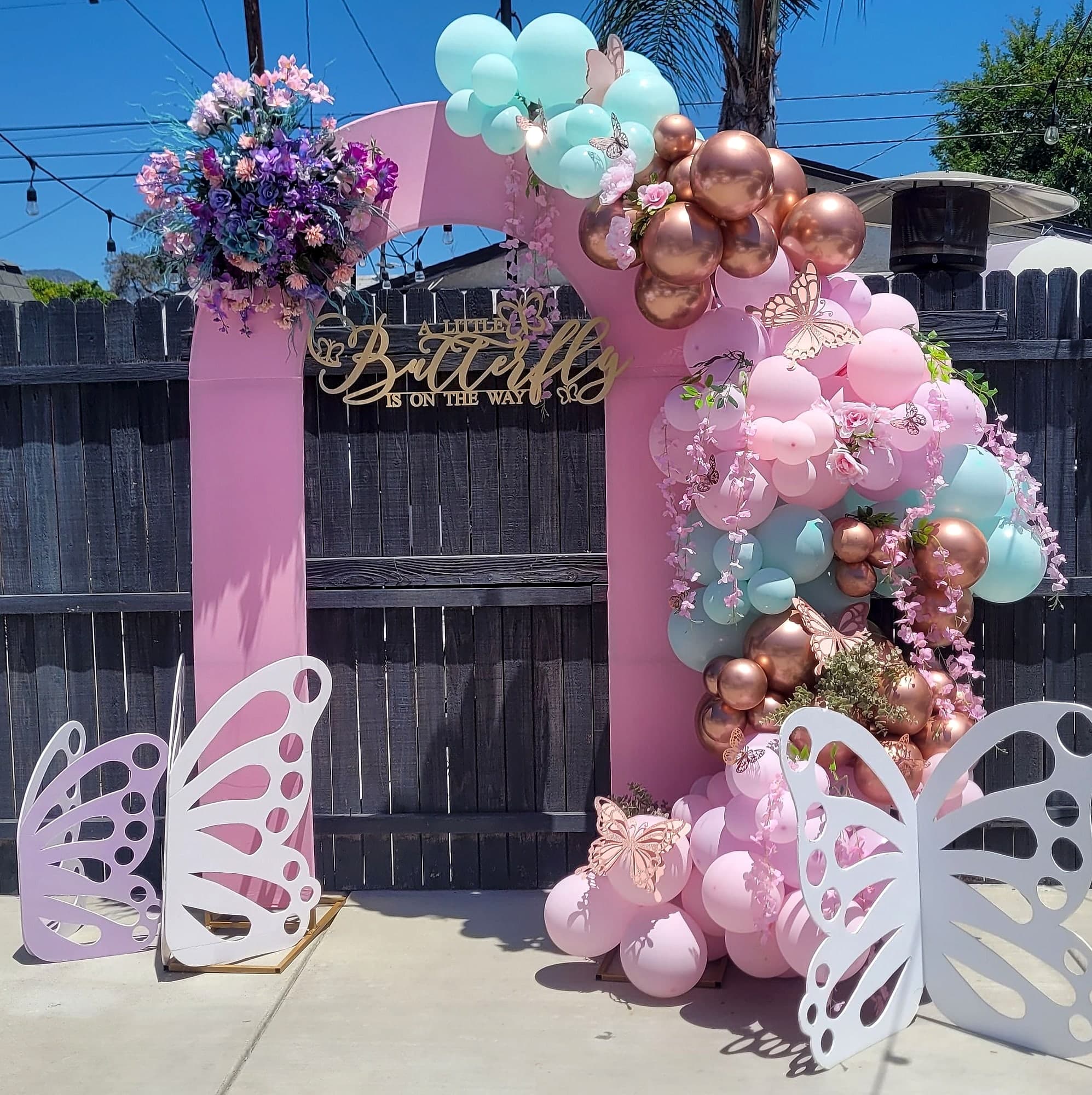 Pink and mint balloon arch with butterflies for a baby shower.