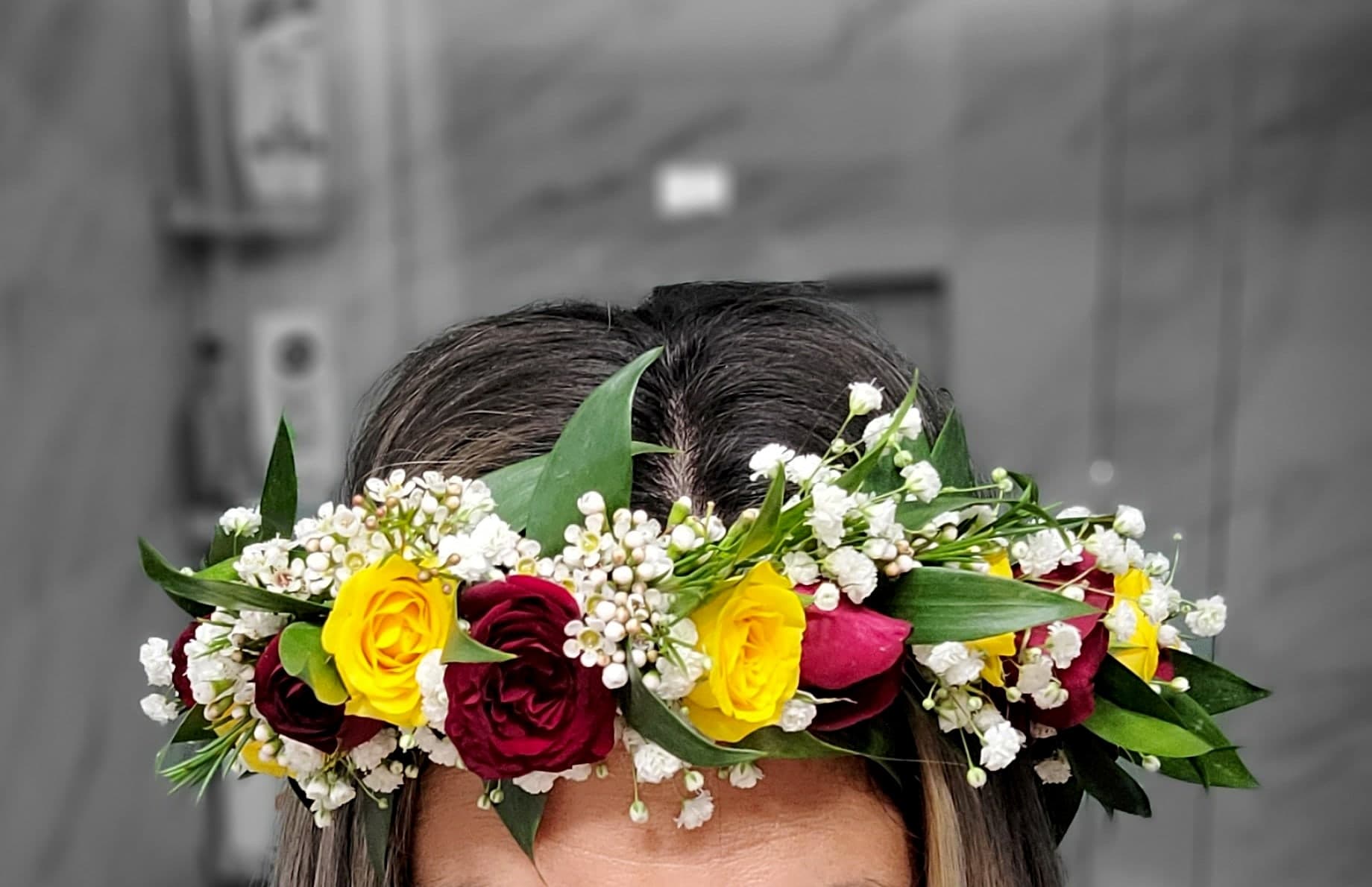 Flower crown of yellow and deep red roses with white waxflower and green ruscus leaves, worn on the head